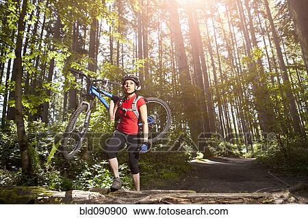 Hispanic woman carrying mountain bike in forest View Large Photo Image Stock Image - Hispanic woman carrying mountain bike in forest. Fotosearch