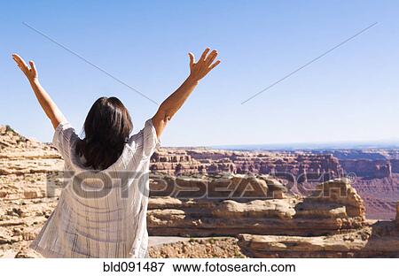 Hispanic woman cheering near canyon View Large Photo Image Stock Photo - Hispanic woman cheering near canyon. Fotosearch