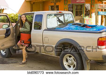 Stock Image - Hispanic woman getting out of truck. Fotosearch
