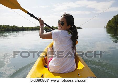 Stock Photo - Hispanic woman paddling kayak. Fotosearch