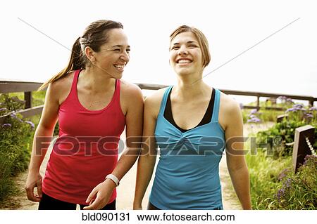 Stock Image - Laughing athletic friends standing together outdoors. Fotosearch
