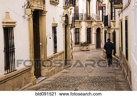 Man walking down cobblestone alley in quaint village View Large Photo Image Stock Image - Man walking down cobblestone alley in quaint village. Fotosearch