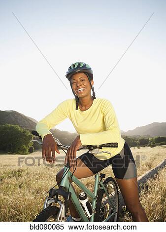 Mixed race biker standing with mountain bike View Large Photo Image Stock Photography - Mixed race biker standing with mountain bike. Fotosearch