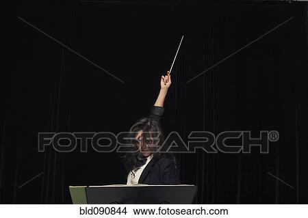 Mixed race conductor pointing baton View Large Photo Image Picture - Mixed race conductor pointing baton. Fotosearch
