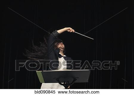 Stock Photography - Mixed race conductor pointing baton. Fotosearch