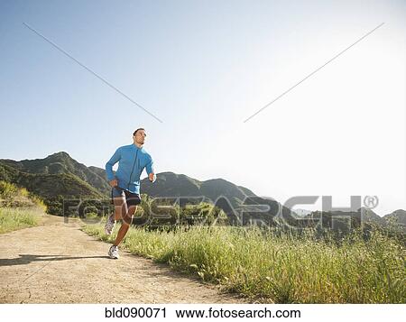 Stock Image - Mixed race man running on remote trail. Fotosearch