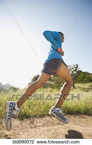 Stock Image - Mixed race man running on remote trail. Fotosearch