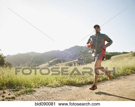 Stock Image - Mixed race man running on remote trail. Fotosearch