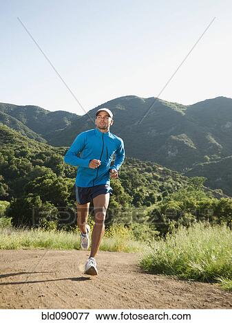 Stock Photo - Mixed race man running on remote trail. Fotosearch