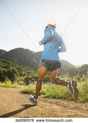 Stock Photo - Mixed race man running on remote trail. Fotosearch