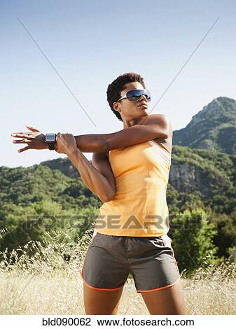 Mixed race runner stretching in field before exercise View Large Photo Image Stock Image - Mixed race runner stretching in field before exercise. Fotosearch