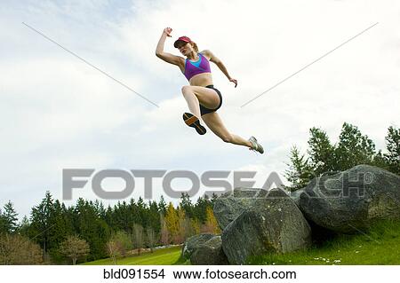 Mixed race teenager jumping from rock View Large Photo Image Picture - Mixed race teenager jumping from rock. Fotosearch