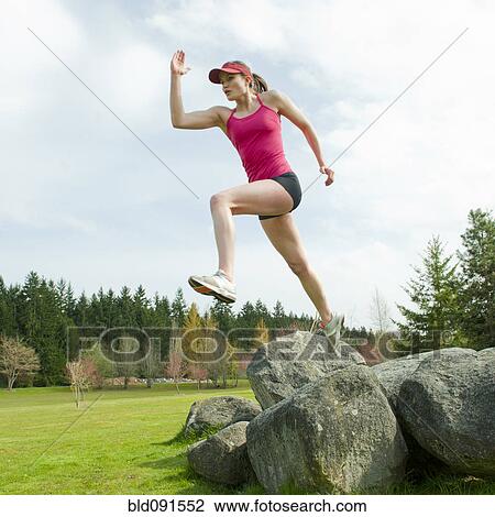 Mixed race teenager jumping from rock View Large Photo Image Stock Image - Mixed race teenager jumping from rock. Fotosearch