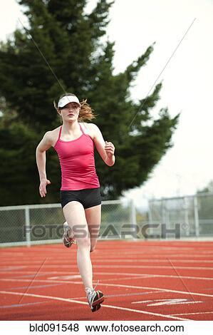 Stock Photo - Mixed race teenager running on track. Fotosearch