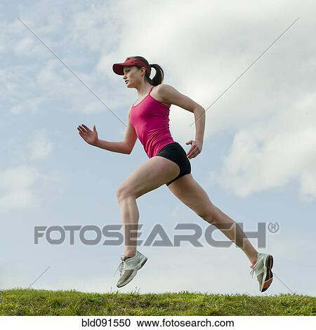 Stock Image - Mixed race teenager running outdoors. Fotosearch