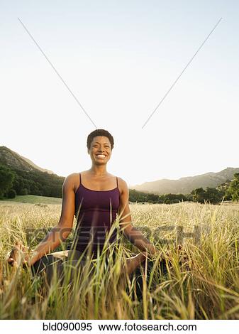 Stock Photography - Mixed race woman practicing yoga in remote field. Fotosearch