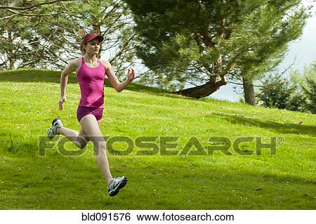 Stock Photograph - Mixed race woman running downhill. Fotosearch