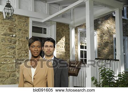 Stock Photography - Multiracial couple standing outside house. Fotosearch