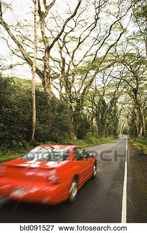 Red car driving down country lane View Large Photo Image Stock Photo - Red car driving down country lane. Fotosearch