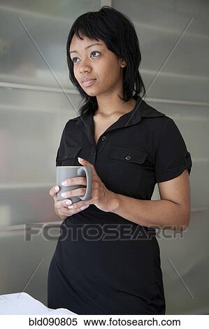 Stock Photography - Serious businesswoman holding coffee cup. Fotosearch