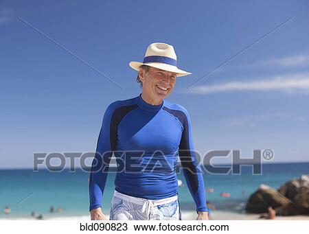 Smiling Caucasian man standing on beach View Large Photo Image Stock Image - Smiling Caucasian man standing on beach. Fotosearch