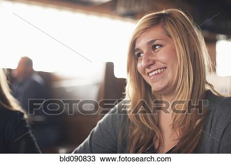 Stock Image - Smiling Caucasian teenager in restaurant. Fotosearch