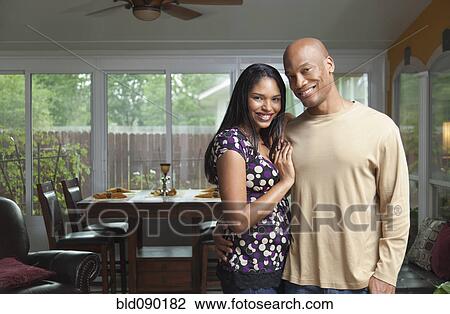 Smiling couple standing in dining room View Large Photo Image Stock Image - Smiling couple standing in dining room. Fotosearch