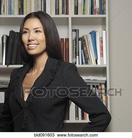 Smiling Japanese woman near bookcase View Large Photo Image Stock Image - Smiling Japanese woman near bookcase. Fotosearch