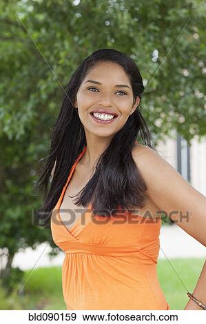 Stock Photo - Smiling mixed race woman standing outdoors. Fotosearch