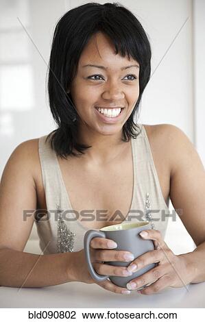 Stock Image - Smiling woman drinking coffee. Fotosearch