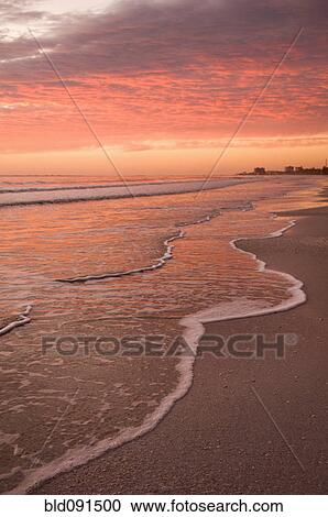 Stock Image - Sunset over tranquil beach. Fotosearch