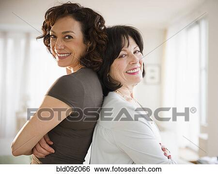 Stock Photograph - Adult daughter and mother standing back to back. Fotosearch