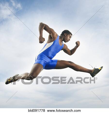 Stock Photo - African American athlete jumping in mid-air. Fotosearch