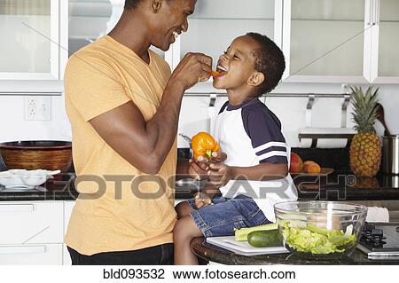 African American father and son eating vegetables in kitchen View Large Photo Image Stock Image - African American father and son eating vegetables in kitchen. Fotosearch