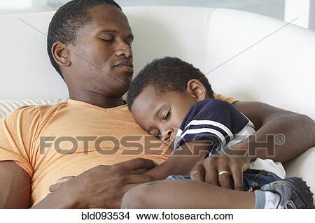 African American father napping on sofa with son View Large Photo Image Picture - African American father napping on sofa with son. Fotosearch