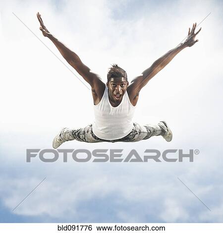 Stock Photograph - African American man jumping in mid-air. Fotosearch