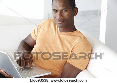 Stock Photo - African American man typing on laptop. Fotosearch
