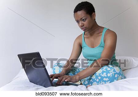 African American woman using laptop in bed View Large Photo Image Stock Photo - African American woman using laptop in bed. Fotosearch