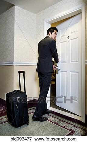 Stock Photo - Asian businessman entering hotel room. Fotosearch