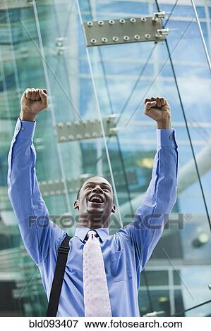 Stock Photo - Black businessman cheering outdoors. Fotosearch