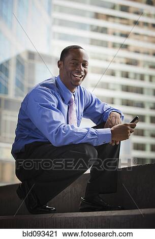 Black businessman holding cell phone View Large Photo Image Stock Image - Black businessman holding cell phone. Fotosearch