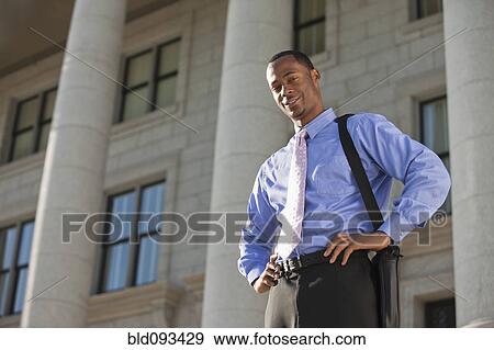 Black businessman standing outdoors with hands on hips View Large Photo Image Stock Photo - Black businessman standing outdoors with hands on hips. Fotosearch