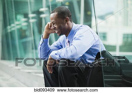 Stock Photo - Black businessman talking on cell phone outdoors. Fotosearch