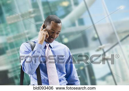 Stock Photograph - Black businessman talking on cell phone outdoors. Fotosearch