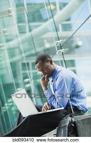 Black businessman using laptop outdoors View Large Photo Image Stock Image - Black businessman using laptop outdoors. Fotosearch