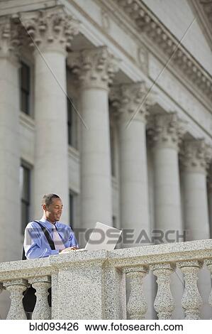Black businessman using laptop outdoors View Large Photo Image Stock Photograph - Black businessman using laptop outdoors. Fotosearch