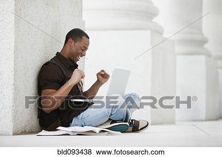 Stock Photo - Black college student using laptop outdoors. Fotosearch