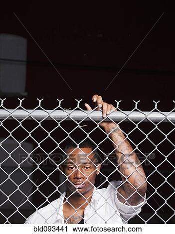 Black man leaning on chain link fence View Large Photo Image Stock Image - Black man leaning on chain link fence. Fotosearch