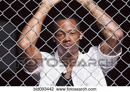 Black man leaning on chain link fence View Large Photo Image Stock Image - Black man leaning on chain link fence. Fotosearch