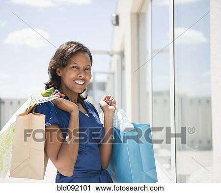 Black woman carrying shopping bags View Large Photo Image Stock Image - Black woman carrying shopping bags. Fotosearch